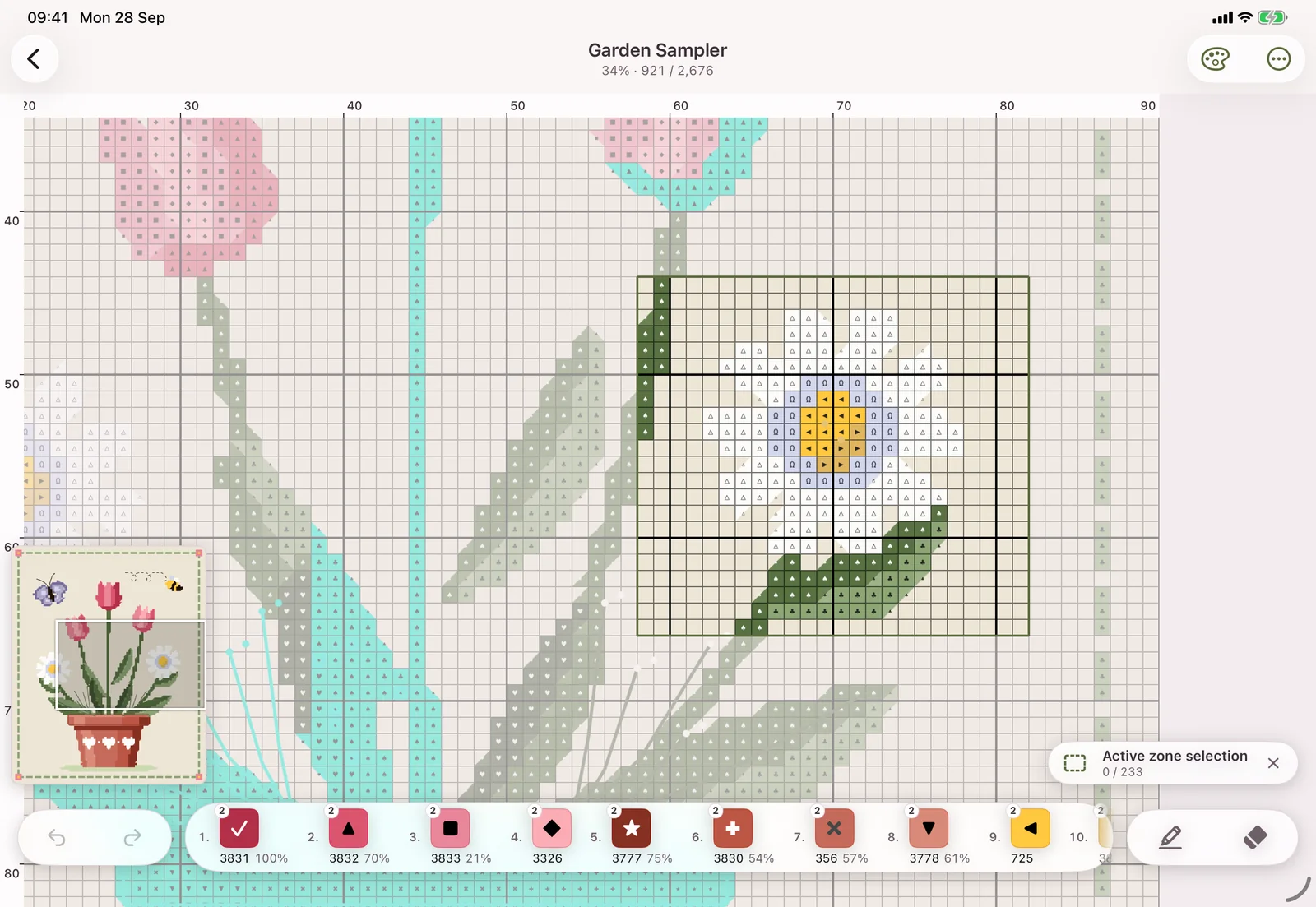 A work region selected around a daisy on a cross-stitch chart on iPad, the rest of the chart faded